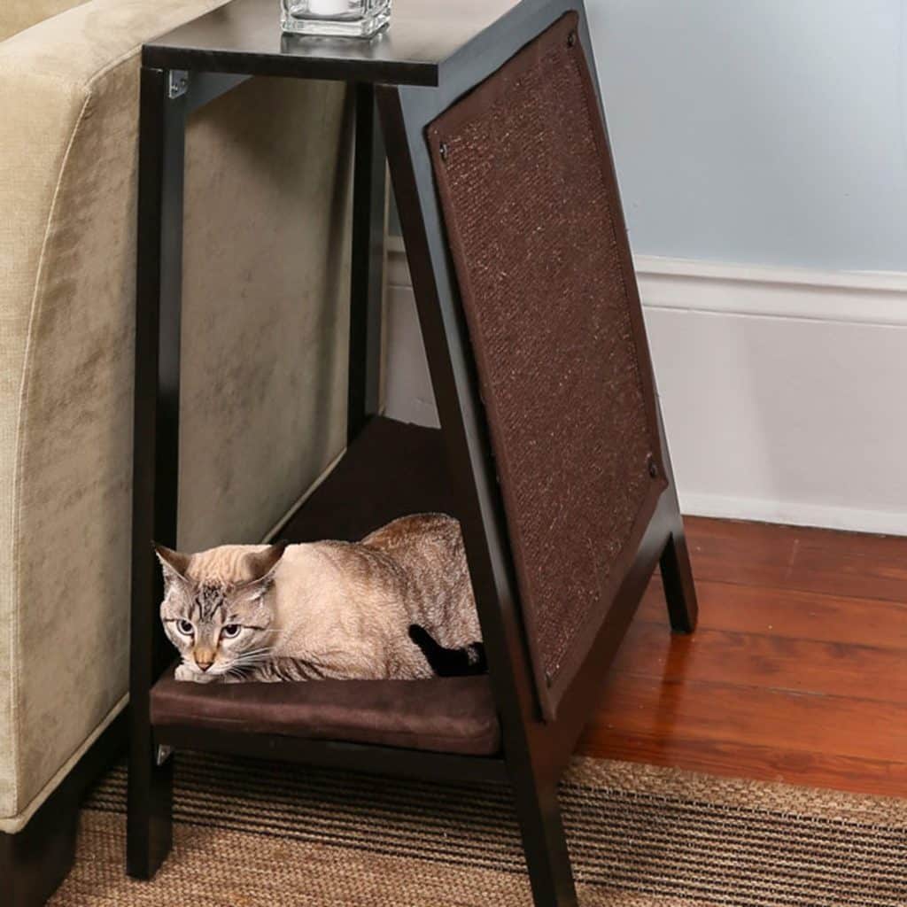 Cat lying on a modern A-Frame Cat Bed Espresso under a side table next to a sofa and textured rug.