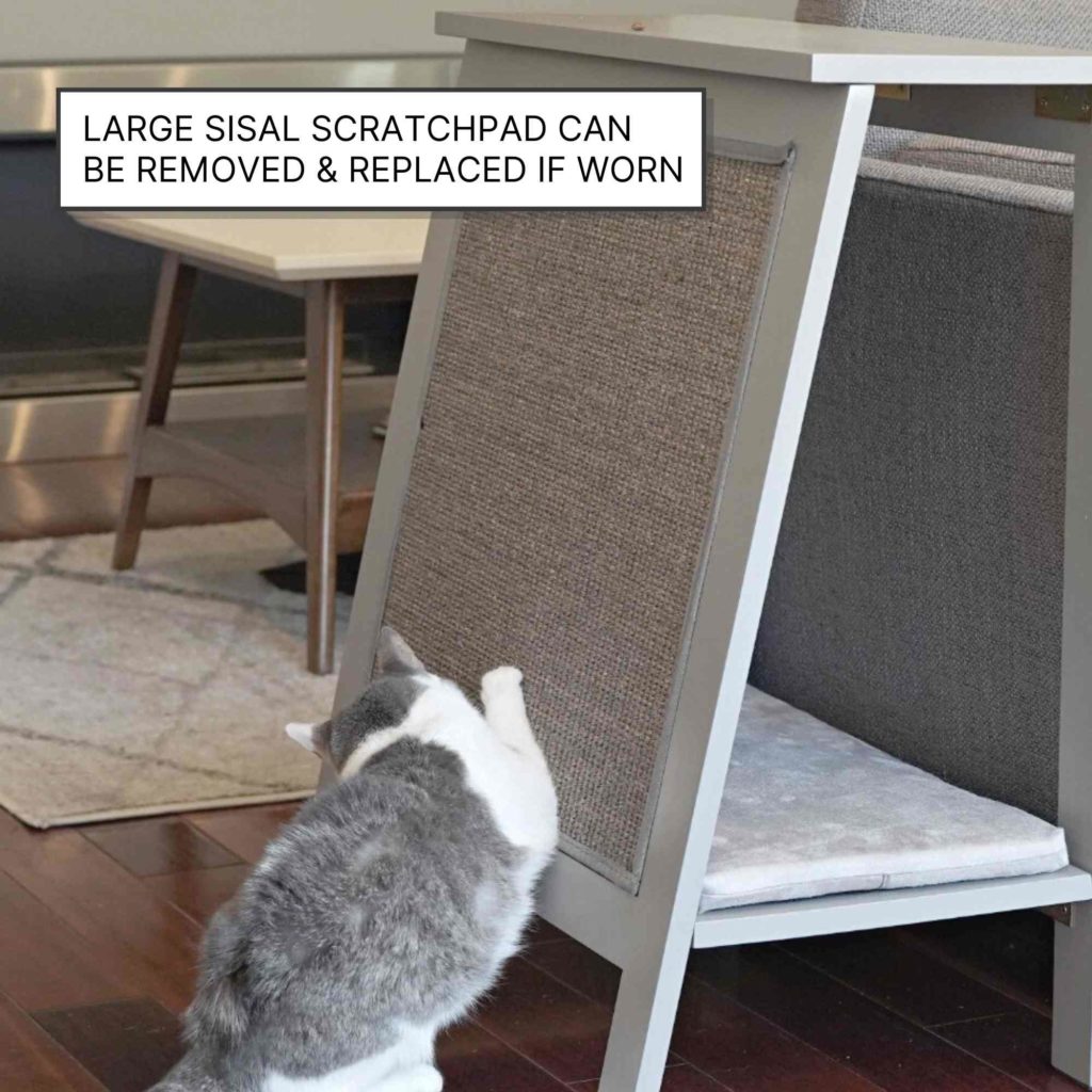 Cat scratching a large sisal pad on an A-frame wooden cat bed; sign indicates pad is removable and replaceable.