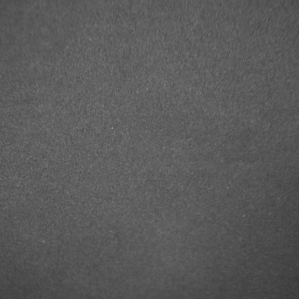 Close-up of dark grey Smoke fabric with a subtle visible texture and diagonal weave pattern.