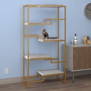 Cat on the middle platform of a gold-frame, white-platform, gray-cushion cat tree in a stylish blue-walled living room.