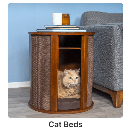 5 A fluffy cat relaxes in a circular wooden end table with a built-in bed beside a sofa in a festively decorated living room.