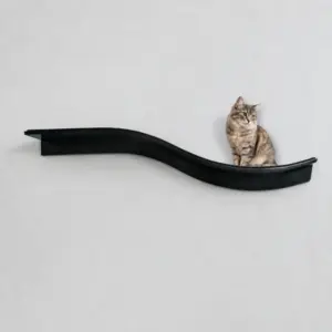 Tabby cat sitting on a dark, wavy lotus leaf-shaped shelf mounted on a plain light gray wall.