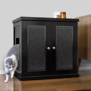 Gray and white cat leaving a side-opening cabinet with two jars on top, next to wood furniture on hardwood floor.