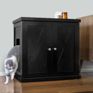 Gray and white cat leaving a black cabinet with double doors on a wood floor next to brown furniture.