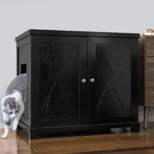 Gray and white cat leaving the side opening of a black cabinet with double doors on a wooden floor beside furniture.