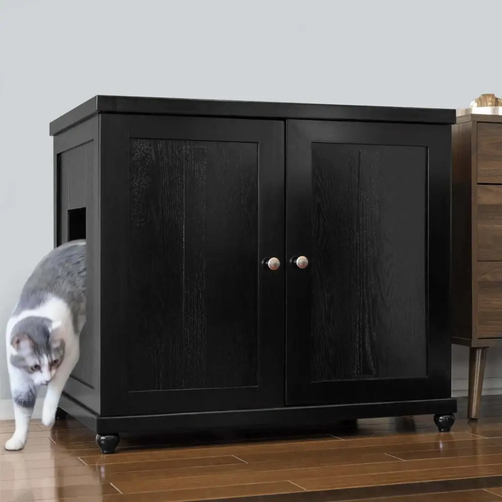 Black wooden cabinet with two doors and side opening on wooden floor, cat walking out through the side entrance.